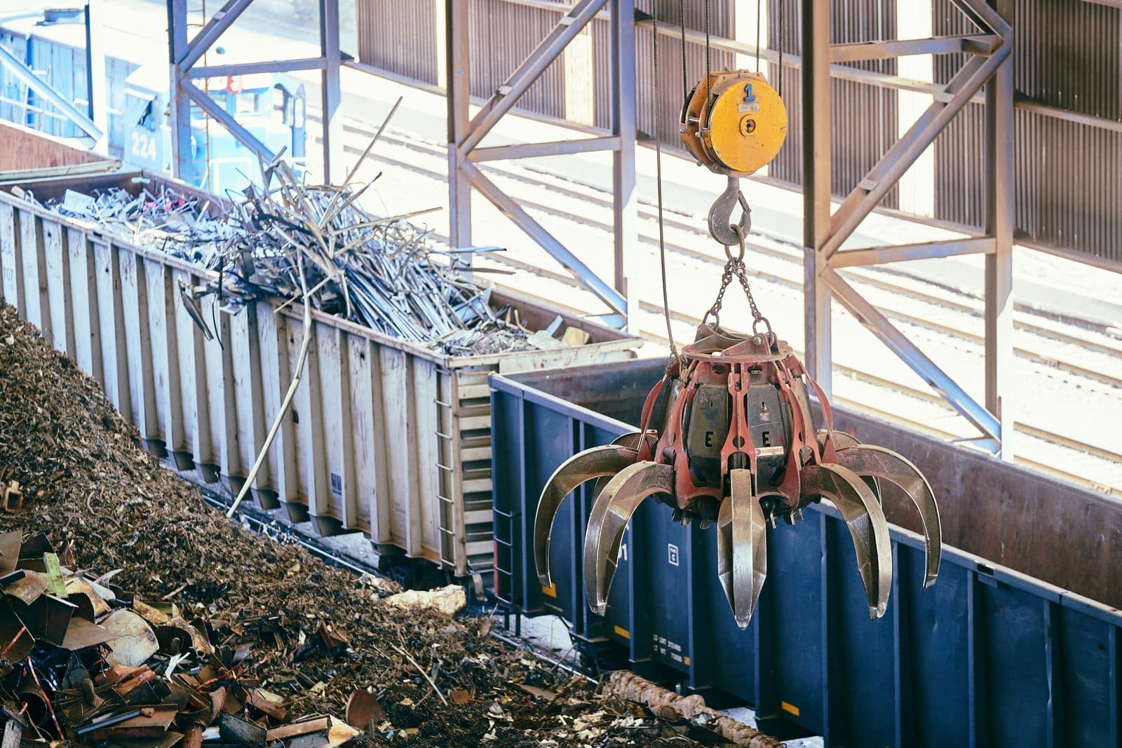 Overhead crane sorting scrap metal inside a recycling facility